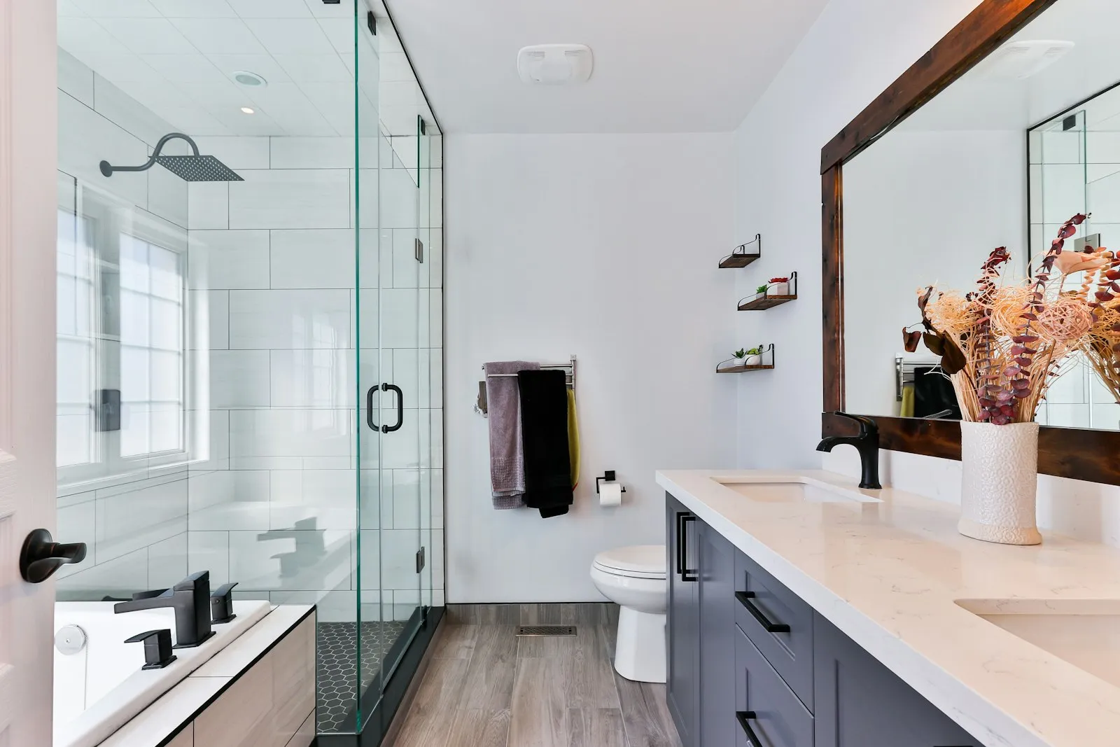 A spotless bathroom with a glass shower and marble counter after a deep cleaning